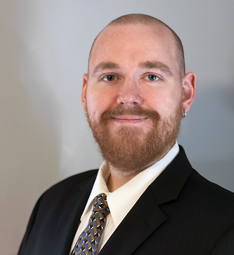 Headshot showing David Omstead in a suit smiling casually